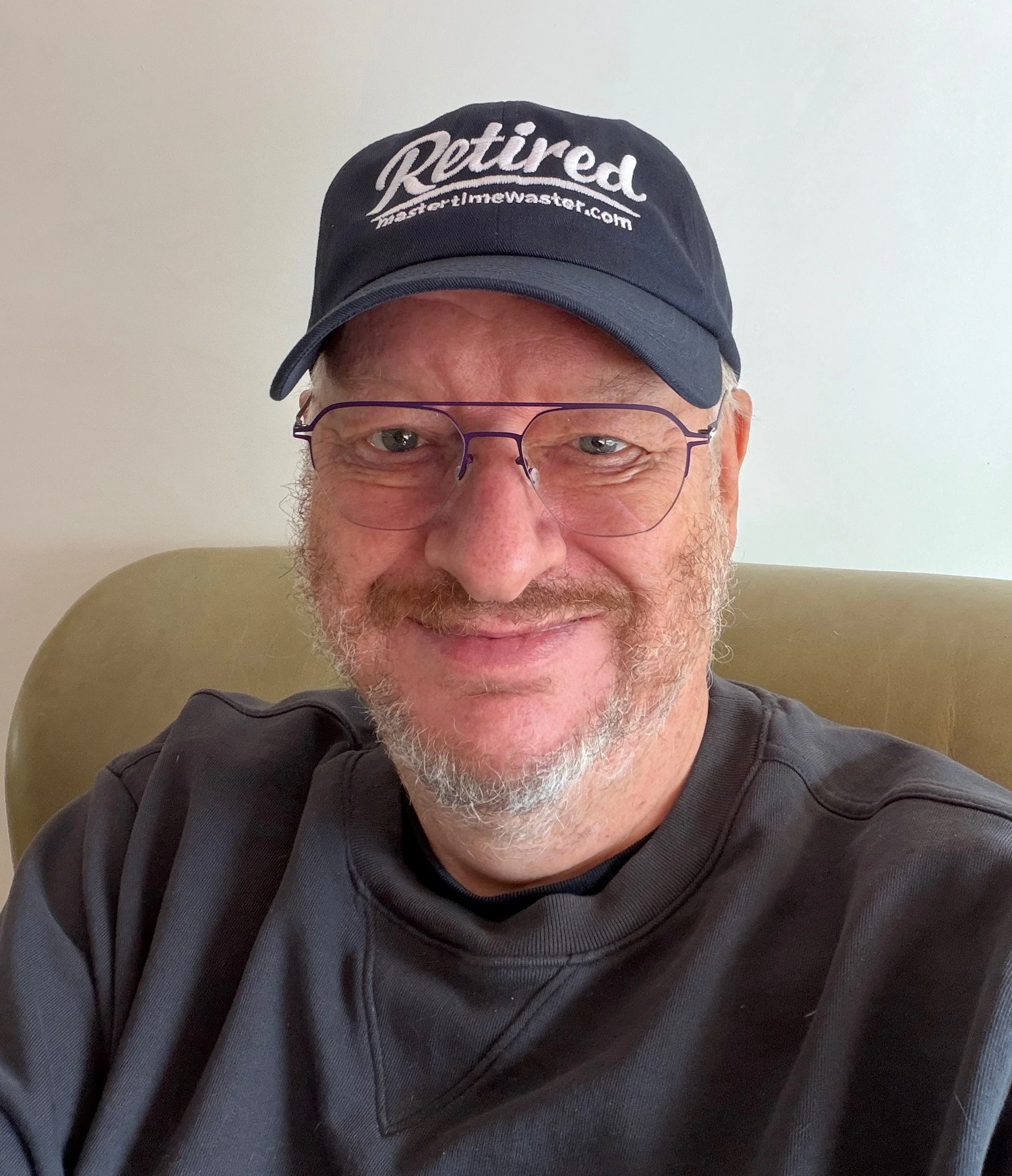 A smiling person wearing a retired cap